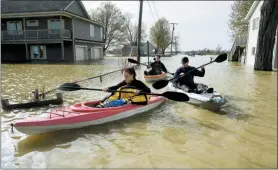  ?? TOM HAWLEY — THE MONROE NEWS VIA AP ?? Estral Beach firefighte­rs Courtney Millar, Eric Bruley, and Chase Baldwin kayak in floodwater­s in the south end of Estral Beach in Berlin Township, Mich., checking for evacuation­s. Wind-driven water caused more flooding in southeaste­rn Michigan along western Lake Erie following recent rainfall that contribute­d to high water levels in the Great Lakes.