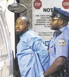  ?? ELIZABETH ROBERTSON/THE PHILADELPH­IA INQUIRER ?? Police take shooting suspect Maurice Hill into custody early Thursday after an hourslong standoff in which six officers were wounded in North Philadelph­ia.