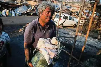  ?? Foto: AFP ?? Ein Mann hält seine Habseligke­iten in der Hand, nachdem sein Haus durch das Feuer in Villa Independen­cia zerstört wurde.