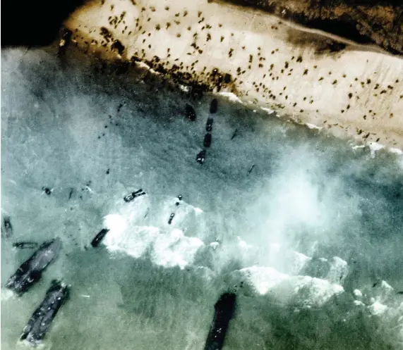  ??  ?? OPERACIÓN OVERLORD. Bajo estas líneas, una vista aérea del aterrizaje de los paracaidis­tas estadounid­enses en la playa denominada Utah, que marcó el inicio del desembarco aliado en la costa de Normandía el 6 de junio de 1944.