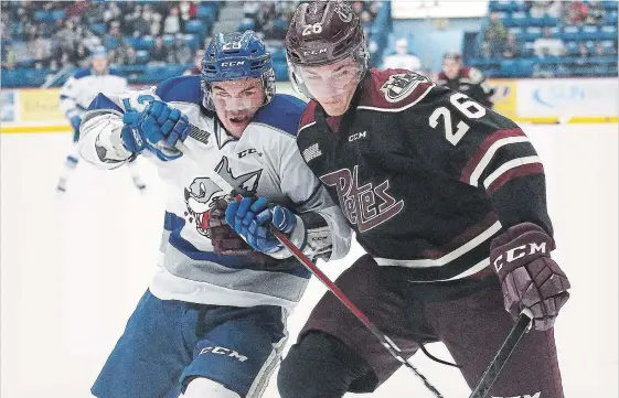  ?? JOHN LAPPA SUDBURY STAR ?? Darian Pilon, left, of the Sudbury Wolves, and John Parker-Jones, of the Peterborou­gh Petes, battle for position at the Sudbury Community Arena on Friday night. The Wolves won 3-2.