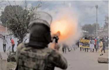  ?? — PTI ?? A policeman fires teargas shells to disperse protesters during a clash, which erupted after Id prayers, in Srinagar.