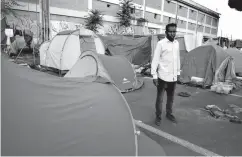  ?? Associated Press ?? ■ An asylum seeker from the Horn of Africa who did not want to be identified by his name sits in a tented camp set up by the Baobad aid group Tuesday on the outskirts of Rome. After dramatical­ly blocking the humanitari­an group’s ships from bringing...