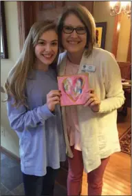  ??  ?? Painting: Spirit of Community distinguis­hed finalist Emmaline Landes is pictured with Northwest Elementary literacy chair Jodie Walker, who purchased a Heart for a Valentines Day 2017 ALS Fundraiser.