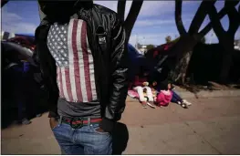 ?? GREGORY BULL — AP PHOTO ?? A migrant asylum seeker from Haiti waits at a makeshift camp of migrants at the border port of entry leading to the United States on Wednesday in Tijuana, Mexico. The migrant camp shows how confusion has undercut the message from President Joe Biden that it’s not the time to come to the United States.