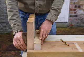  ??  ?? 2 Lay two 1,500mm planks side by side to form the front panel. To get the exact position for the corner post, stand one 320mm end plank in place, aligned using a set square, and but the post up against it.