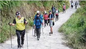  ?? — Reuters ?? To safety: Hikers making their way down from Mount Rinjani at Sembalun village in Lombok Timur, Indonesia.