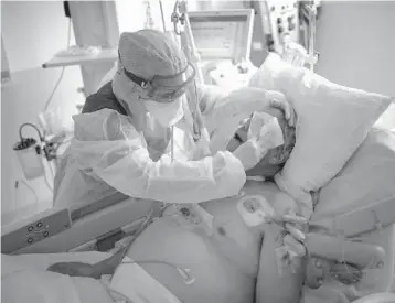  ?? DANIEL COLE/AP ?? A nurse cleans a COVID-19 patient in February in Marseille, France. The number of people who died from COVID-19 passed 3 million on Saturday with France alone accounting for almost 101,000 deaths. Over 566,000 have died in the U.S.