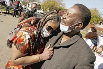  ?? Photograph­s by Al Seib Los Angeles Times ?? SHINESE HARLINS Kilgore, cousin of Latasha Harlins, is hugged by her stepfather, David Bryant, as family, close friends and community members mark the 30th anniversar­y of the teen’s fatal shooting.