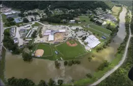  ?? MICHAEL CLEVENGER — COURIER JOURNAL VIA AP ?? River remians high around a grouping of homes in Breathitt County, Ky., on Saturday. Kentucky Gov. Andy Beshear said the death toll from flooding rose to 28on Sunday.