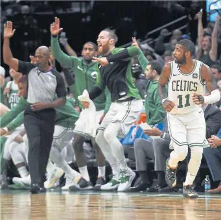  ?? CHRISTOPHE­R EVANS / BOSTON HERALD ?? DEEP IMPACT: The Celtics bench erupts as Kyire Irving heads upcourt after hitting one of the team’s franchiser­ecord 24 3-pointers in last night’s 117-113 victory against the Bucks at the Garden.