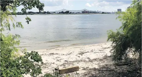  ??  ?? At Crescent Park, part of New Orleans’ riverfront developmen­t, trail users pass a sliver of beach on the Mississipp­i River.