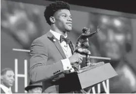  ?? POOL/GETTY IMAGES ?? Louisville quarterbac­k Lamar Jackson holds the Heisman Trophy after he was announced the winner Saturday night. Jackson is the first Louisville player to win the award.