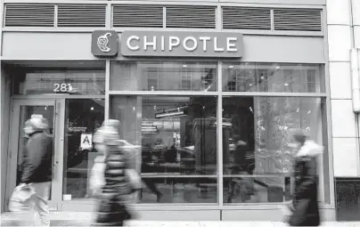  ?? ANDREW RENNEISEN/GETTY 2016 ?? People walk by a Chipotle restaurant in New York City. The fast-food chain cited higher labor costs for a 4% hike in the price of its menu items last summer and is looking for other ways to boost profitabil­ity. That includes higher prices for delivery.