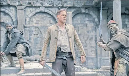  ?? [WARNER BROS. PICTURES PHOTOS] ?? King Arthur (Charlie Hunnam) with his sword MPAA rating: Running time: Now showing