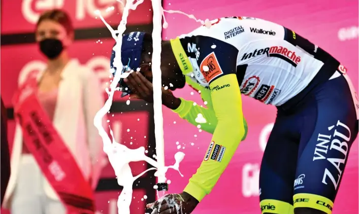  ?? Photo / AP ?? Eritrean cyclist Biniam Girmay grimaces on the podium after a champagne cork hit his left eye. He has been forced to withdraw from the Giro d’Italia.