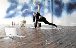  ?? Melissa Phillip / Staff photograph­er ?? Sarah Gordon leads a livestream yoga class at Atrium Yoga Studio, which started offering livestream­ed classes on Monday.