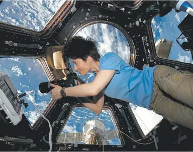  ?? ESA / NASA ?? Samantha Cristofore­tti works her camera on the space station. Top, her photo of London.