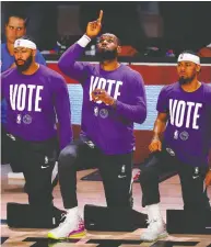  ?? MIKE EHRMANN / GETTY IMAGES ?? LeBron James, centre, of the Los Angeles Lakers, kneels during the National Anthem before a playoff game this week. The NBA star has been outspoken about the need
for society to address the issue of racism.