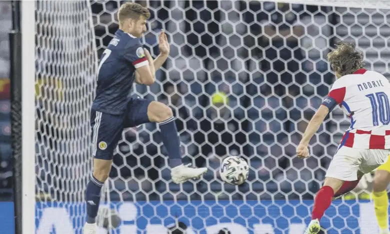  ??  ?? 0 Croatia playmaker Luka Modric curls the ball home to make it 2-1 to the visitors at Hampden Park last night as Scotland’s hopes of reaching the last 16 ended in heartbreak­ing fashion