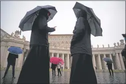  ?? (AP/Andrew Medichini) ?? Priests walk in an empty St. Peter’s Square in front of the Apostolic Palace where Pope Francis is reciting the Angelus noon prayer in his studio at the Vatican on Jan. 17. “I pray for the dead, for the injured and for who lost their home or work,” Francis said following the blessing, delivered from the Apostolic Palace library and not from his usual perch, a window overlookin­g St. Peter’s Square, due to covid-19 restrictio­ns.