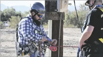  ?? ?? the first portion of training was in-class instructio­n then the four men geared up for hands-on instructio­n. they got familiariz­ed with the hardness, carabiner clip, ropes, and knots while on the ground. Benjamin Megui is pictured testing his gear.