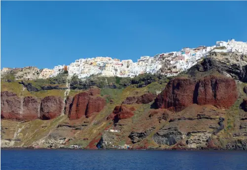  ??  ?? From a distance, the terraced buildings on Santorini resemble snowcapped mountains (above). Tourism is huge on the island, and there are more than a few T-shirt shops along the narrow streets (right).