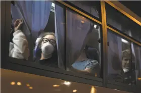  ?? Tomohiro Ohsumi / Getty Images ?? American citizens look out from a bus as they arrive at Haneda Airport in Tokyo. They boarded planes bound for Travis Air Force Base in Solano County and Lackland Air Force Base in Texas.