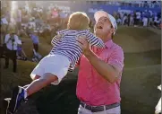  ?? MARCIO JOSE SANCHEZ/ASSOCIATED PRESS ?? Hudson Swafford lifts his son James after winning the American Express golf tournament on the Pete Dye Stadium Course at PGA West, Sunday, in La Quinta, Calif.