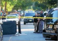  ?? PENNY RAY - TRENTONIAN ?? A black curtain surrounds a dead body found inside a bag on the side of the road in the 400 block of Lamberton Street Monday afternoon.