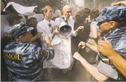  ?? AP ?? In June, riot police detain gay rights activists Maxim Lysak and Jury Gavrikov during an authorized gay rights rally in St. Petersburg, Russia.