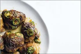  ?? MILK STREET VIA AP ?? This image released by Milk Street shows a recipe for glazed chicken thighs, seasoned with jalapenos and apricot preserves. A dusting of earthy cumin on the chicken before roasting helps ground the flavors and balance the brighter sweetness of the preserves.