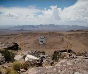  ?? AP FILE PHOTO BY JOHN LOCHER ?? A sign warns of a falling danger on the crest of Yucca Mountain during a congressio­nal tour near Mercury, Nev. Nevada’s governor and congressio­nal delegation say recent earthquake­s should make the U.S. Energy Department look again at seismic risks at a site eyed as the place to bury the nation’s nuclear waste, Wednesday.