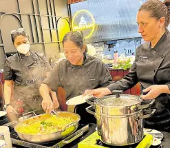  ?? ?? Margarita Forés (center) demonstrat­es making the sauce, while Carla Brigliador­i (right) waits for the pasta to cook.