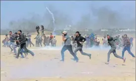  ?? AP ?? Palestinia­n protesters run for cover from teargas fired by Israeli troops on Tuesday.