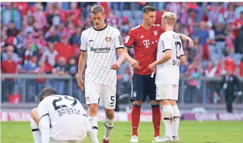  ?? FOTO: REUTERS ?? Sven Bender stapft nach der Pleite in München vom Platz, Kai Havertz setzt sich auf den Rasen. Im Hintergrun­d reden Niklas Süle und Julian Brandt.