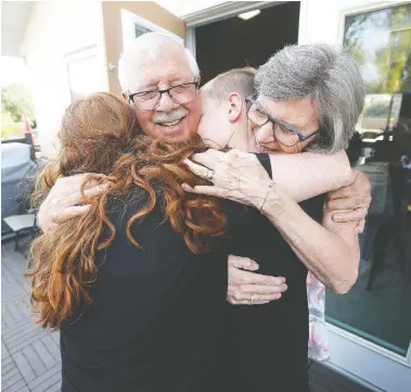  ?? JOHN WOODS / THE CANADIAN PRESS ?? Richard and Linda Davis hug their grandchild­ren Miles and Linda Carnegie for the first time in fifteen months
at their home in Winnipeg on Sunday, after Manitoba lifted some COVID-19 restrictio­ns this weekend.