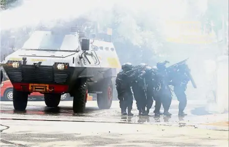  ?? — Reuters ?? Tense situation: Police surroundin­g a government office after an explosion in Bandung, West Java.