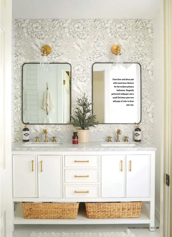  ?? ?? Clean lines and décor pair with warm brass fixtures for the modern primary bathroom. Elegantly patterned wallpaper and a small Christmas pine tree add pops of color to draw your eye.