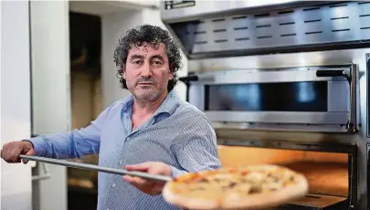  ?? Foto: Steffen Unger ?? Frisch aus dem Ofen kommt die handwerkli­ch gefertigte Pizza bei Nino Milazzo. Dem Pizza- Bäcker können die Kunden am Bautzener Holzmarkt über die Schultern schauen.