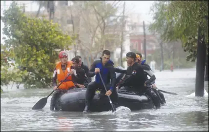  ?? AP PHOTO ?? Members of a rescue team navigate a flooded street Havana after the passage of Hurricane Irma in Cuba on Sunday. The powerful storm ripped roofs off houses, collapsed buildings and flooded hundreds of miles of coastline after cutting a trail of...