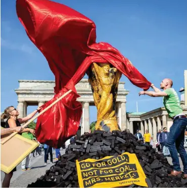  ?? Foto: dpa/Kay Nietfeld ?? Zum Petersberg­er Klimadialo­g enthüllen Aktivisten in Berlin einen Pokal auf einem Kohlehaufe­n.