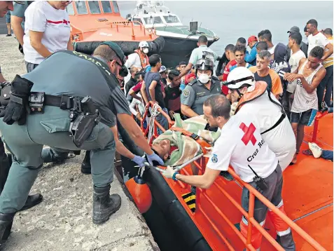  ??  ?? Members of the Spanish Red Cross and Civil Guard assist a man who was rescued by the Spanish Maritime Rescue Services, on his arrival at Tarifa in Cadiz in August; top left, Helena Maleno Garzón, the activist