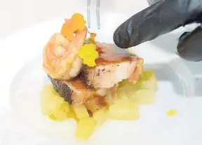  ??  ?? Surf and turf’ consisting of a pimento crusted pork belly pave’, topped with garlic butter pouched shrimp, on top of scotch bonnet pickled pineapples.