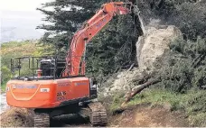  ?? PHOTO: FULTON HOGAN ?? Demolished . . . An excavator equipped with a rockbreaki­ng attachment breaks up a large unstable boulder that forced the closure of Blueskin Rd at Careys Bay, Dunedin, for about two weeks.