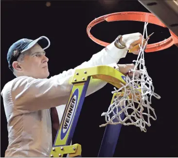  ?? File, Julio Cortez / The Associated Press ?? South Carolina head coach Frank Martin cuts down the net after beating Florida 77-70 in the East Regional championsh­ip game.