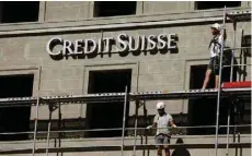  ?? — AFP ?? Workers are seen in scaffoldin­g infront of Credit Suisse bulding in Zurich.