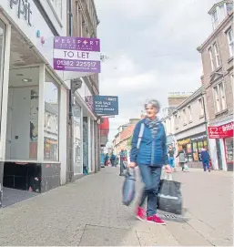  ?? Picture: Kim Cessford. ?? A shopper in Arbroath High Street. Covid-19 restrictio­ns saw shops pull down the shutters.