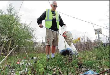  ?? Christian Abraham / Hearst Connecticu­t Media ?? Volunteer Joe Mauro cleans up trash along North Division Street in Ansonia on Saturday as part of Earth Day.