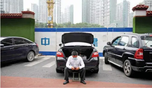  ?? Agence France-presse ?? ↑
A driver waits near his car in Beijing on Friday.